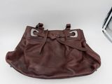 brown leather purse with metal buckles on a white surface