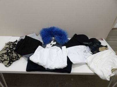 une table blanche sur laquelle sont posés un tas de vêtements