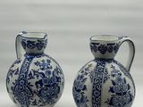 two blue and white vases sitting next to each other