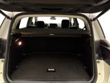 the back of a white car with its trunk open and the back seats down
