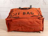 an orange bag sitting on top of a wooden table next to a wall