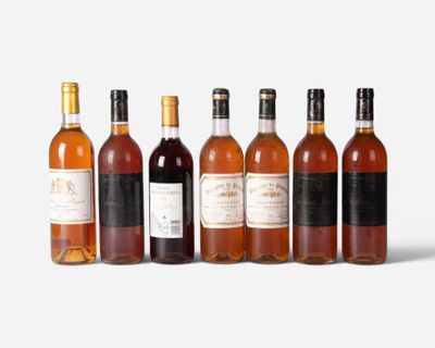 six bottles of wine are lined up in a row on a white surface
