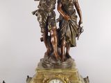 a statue of a man and a woman on a clock