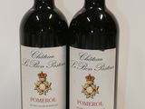 two bottles of red wine sitting next to each other on a table