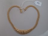 gros plan d'un collier en or sur une surface blanche