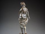 a bronze statue of a woman standing on a marble base