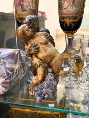 une table en verre sur laquelle se trouvent des vases et une statue