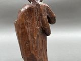 a wooden statue of a man with a hat on his head