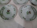four plates with flowers and leaves on them on a table