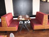 two booths with red seats and a table in the corner