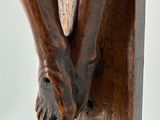 statue of a person holding a cross on a wooden cross