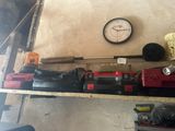 une horloge accrochée au mur, à côté des outils posés sur une étagère