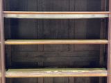 a wooden book shelf with several shelves on it