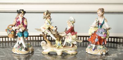 four figurines of people sitting on a table
