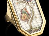 un gros plan d'une bague en or ornée d'un papillon