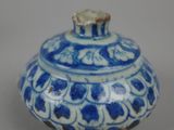 blue and white vase sitting on top of a white table