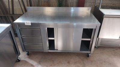 une table de travail en acier inoxydable équipée de tiroirs et d'un réfrigérateur