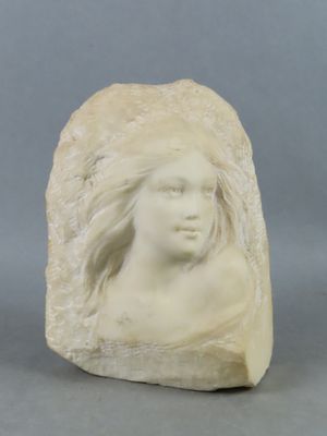 une image représentant une sculpture représentant la tête d'une femme posée sur un rocher