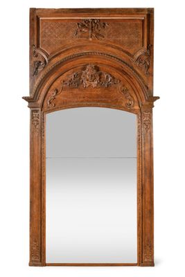 a large carved wood mirror with an arched top