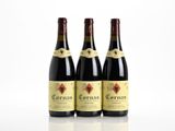 three bottles of red wine sitting on top of a white table