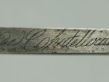 a close up of a knife with writing on it sitting on a table