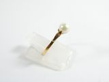 a ring with a pearl sitting on top of a piece of plastic