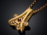 a close up of a gold pendant on a black background