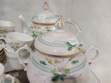 les nombreuses tasses et soucoupes qui se trouvent sur la table