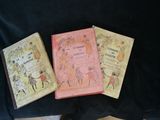 three books that are sitting on a black cloth