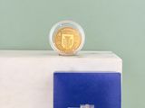une pièce d'or posée sur un livre bleu