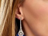 the woman is wearing a pair of earrings with diamonds on them
