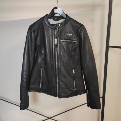 une veste en cuir noir suspendue à un portant dans une pièce
