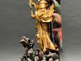 bronze statue of a man holding a sword and a bird on a pedestal