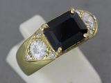 une image représentant une bague en or sertie d'une pierre noire entourée de diamants blancs