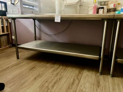 une table sur laquelle est posée une étagère en métal, dans une pièce