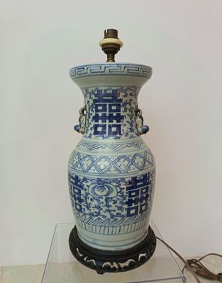 a large blue and white vase on a glass table