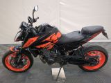an image of a black and orange motorcycle parked on a checkered floor