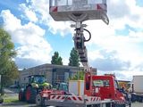 a red truck with a crane on the back of it
