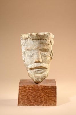 sculpture of a man ' s face on a wooden base