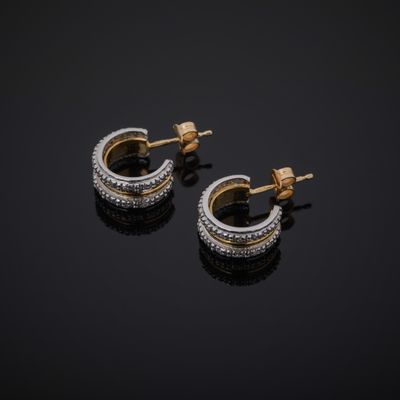 a pair of diamond hoop earrings on a black surface