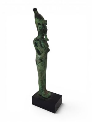 a green statue of a woman with a hat on her head