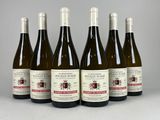 six bouteilles de vin sont alignées sur une table