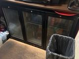 a coffee machine sitting on top of a counter next to a trash can