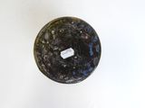 a black vase with a tag on it sitting on a table