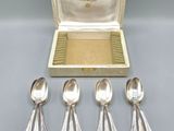 four silver spoons and a box with a silver lid