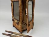 une petite boîte en bois contenant un miroir et une paire de ciseaux