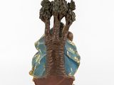 a figurine of a woman sitting on top of a tree