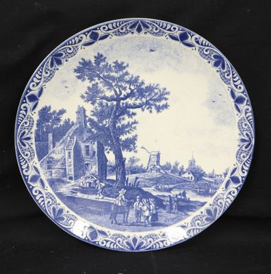 a blue and white plate with a picture of a farm scene on it