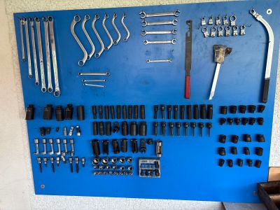 a blue board with a bunch of tools hanging on it