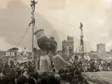 a large crowd of people gathered around a statue of a man